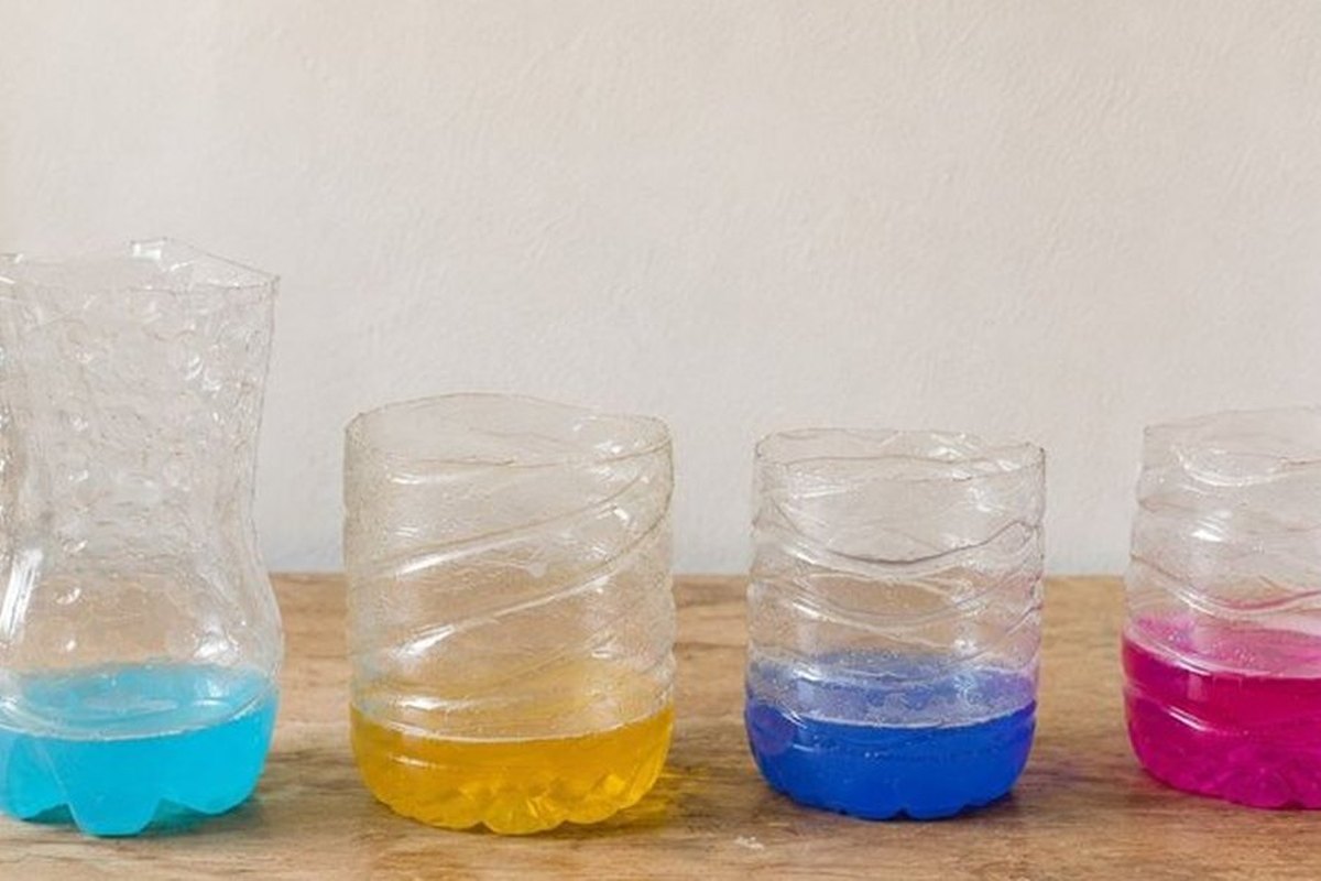 Cut plastic bottles holding water coloured blue, yellow and pink